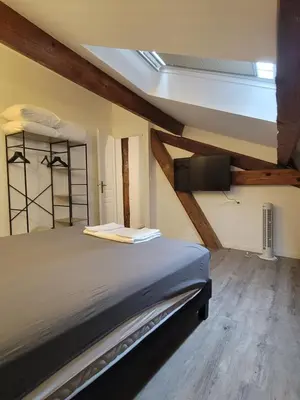 a bedroom with a bed and a tv on the wall at BEAU T3 AU COEUR DU CENTRE VILLE (205) in Narbonne