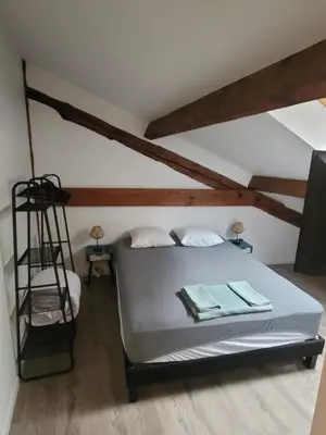 a bedroom with a white bed and wooden beams at BEAU T3 AU COEUR DU CENTRE VILLE (205) in Narbonne