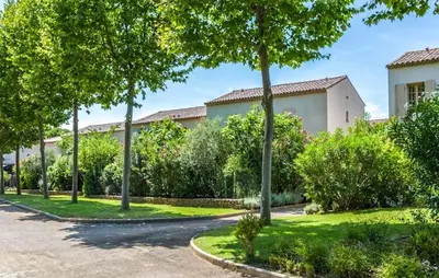 a courtyard with trees and a building at Pet Friendly Home In Saint-Laurent-De-La-Ca in Saint-Laurent-de-la-Cabrerisse