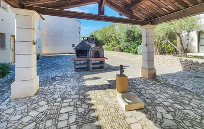 a stone patio with an outdoor grill in a building at Pet Friendly Home In Saint-Laurent-De-La-Ca in Saint-Laurent-de-la-Cabrerisse