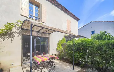 a patio with a table and chairs under an umbrella at Pet Friendly Home In Saint-Laurent-De-La-Ca in Saint-Laurent-de-la-Cabrerisse