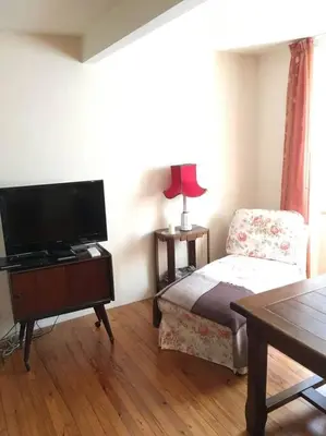 a living room with a tv and a chair at Townhouse in Southern France with a wonderful view and close to a Swimming pool in Axat