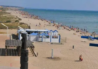 a beach with a crowd of people in the water at Townhouse in Southern France with a wonderful view and close to a Swimming pool in Axat