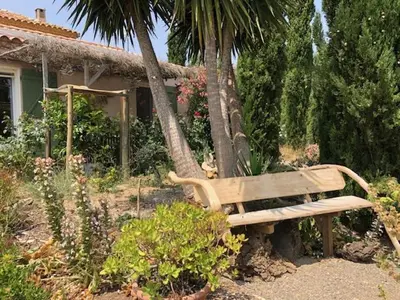 a wooden bench sitting in front of a house at LA LAVANDIERE Famille Amis Relais Motards in Peyriac-de-Mer