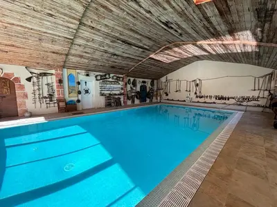 a large swimming pool with a wooden ceiling at Gite LA FONTAINE Famille Amis Relais Motards in Peyriac-de-Mer