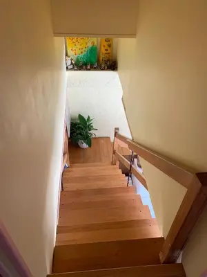 a staircase in a house with wooden floors and a plant at Gite LA FONTAINE Famille Amis Relais Motards in Peyriac-de-Mer