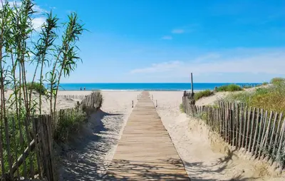 a wooden path to the beach with the ocean in the background at Lovely Home In Saint-Laurent-De-La-Ca in Saint-Laurent-de-la-Cabrerisse