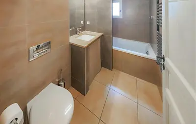 a bathroom with a toilet and a sink and a tub at 2 Bedroom Stunning Home In Saint-Laurent-De-La-Ca in Saint-Laurent-de-la-Cabrerisse