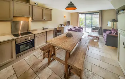 a kitchen with a wooden table and a dining room at 2 Bedroom Stunning Home In Saint-Laurent-De-La-Ca in Saint-Laurent-de-la-Cabrerisse
