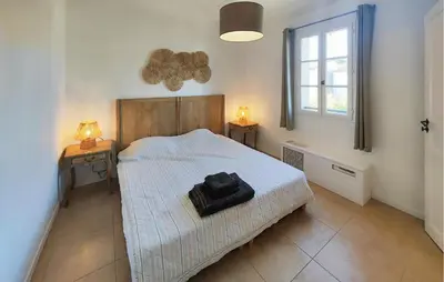 a bedroom with a bed and two tables with lamps at Cozy Home In Saint-Laurent-De-La-Ca With Wifi in Saint-Laurent-de-la-Cabrerisse