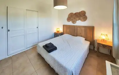 a bedroom with a bed and two night stands and two lamps at Cozy Home In Saint-Laurent-De-La-Ca With Wifi in Saint-Laurent-de-la-Cabrerisse