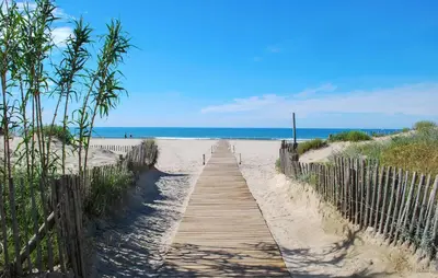 a wooden path to the beach with the ocean in the background at Cozy Home In Saint-Laurent-De-La-Ca With Wifi in Saint-Laurent-de-la-Cabrerisse