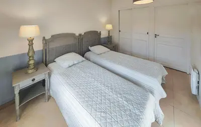 two beds in a bedroom with a lamp and a nightstand at Amazing Home In Saint-Laurent-De-La-Ca With Wifi in Saint-Laurent-de-la-Cabrerisse