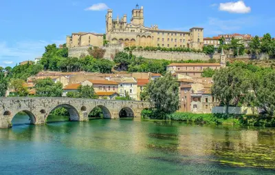 a bridge over a river with a castle in the background at Amazing Home In Saint-Laurent-De-La-Ca With Wifi in Saint-Laurent-de-la-Cabrerisse