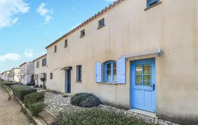 a building with a blue door on a street at Amazing Home In Saint-Laurent-De-La-Ca With Wifi in Saint-Laurent-de-la-Cabrerisse