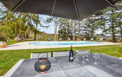 a table with a bottle of wine and wine glasses at 2 Bedroom Cozy Home In Tabre in Tabre