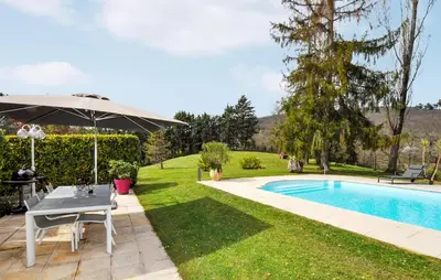 a garden with a table and an umbrella next to a pool at 2 Bedroom Cozy Home In Tabre in Tabre