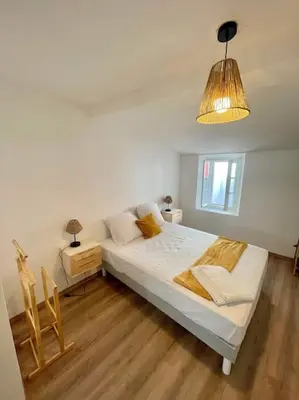 a bedroom with a large bed and a lamp at * Maison chez J&J - Cité médiévale * in Carcassonne