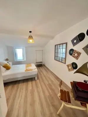 a white room with a bed and records on the wall at * Maison chez J&J - Cité médiévale * in Carcassonne