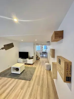 a large living room with a television and a living room with wooden floors at * Maison chez J&J - Cité médiévale * in Carcassonne