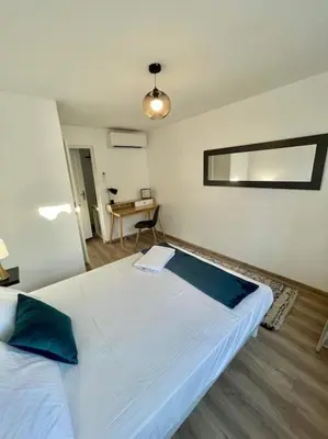 a bedroom with a large white bed with blue pillows at * Maison chez J&J - Cité médiévale * in Carcassonne