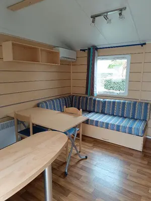 a room with a couch and a table and a bench at MOBIL HOME LUCKY climatisé camping PORT LA NOUVELLE in Port-la-Nouvelle