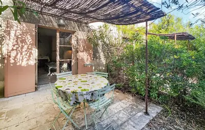 a patio with a table and an umbrella at Pet Friendly Home In Saint-Laurent-De-La-Ca in Saint-Laurent-de-la-Cabrerisse