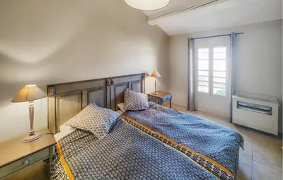 a bedroom with a large bed and a window at 2 Bedroom Lovely Home In Saint-Laurent-De-La-Ca in Saint-Laurent-de-la-Cabrerisse