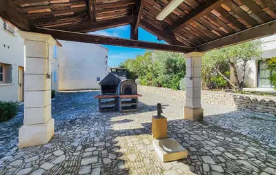 an outdoor patio with a fireplace and a wooden roof at 2 Bedroom Lovely Home In Saint-Laurent-De-La-Ca in Saint-Laurent-de-la-Cabrerisse