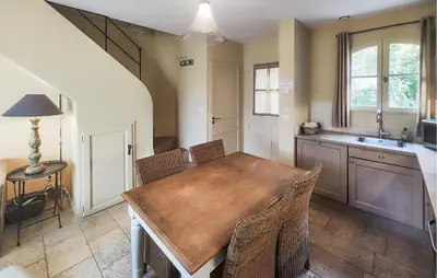 a kitchen with a wooden table and chairs at Nice Home In Saint-Laurent-De-La-Ca in Saint-Laurent-de-la-Cabrerisse