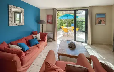 a living room with a red couch and a table at Nice Home In Stlaurent-De-La-Cabr With Wifi in Saint-Laurent-de-la-Cabrerisse