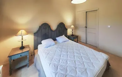 a bedroom with a large bed with a wooden headboard at Nice Home In Stlaurent-De-La-Cabr With Wifi in Saint-Laurent-de-la-Cabrerisse