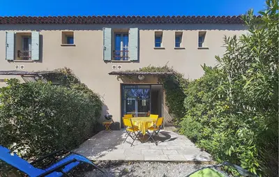 a yellow table and chairs in front of a building at Nice Home In Stlaurent-De-La-Cabr With Wifi in Saint-Laurent-de-la-Cabrerisse