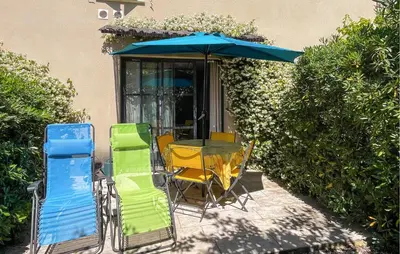 a table and chairs under an umbrella on a patio at Nice Home In Stlaurent-De-La-Cabr With Wifi in Saint-Laurent-de-la-Cabrerisse