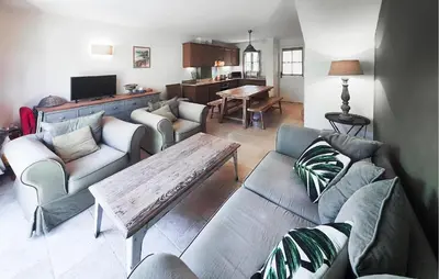 a living room with couches and a wooden table at 2 Bedroom Amazing Home In Stlaurent-De-La-Cabr in Saint-Laurent-de-la-Cabrerisse