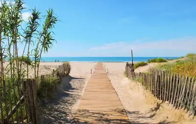 a wooden path to the beach with the ocean in the background at 2 Bedroom Amazing Home In Stlaurent-De-La-Cabr in Saint-Laurent-de-la-Cabrerisse