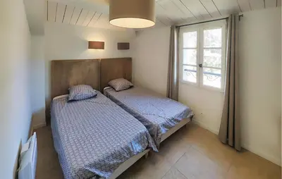 a bedroom with two beds and a window at 2 Bedroom Lovely Home In St-Laurent-De-La-Carbr in Saint-Laurent-de-la-Cabrerisse