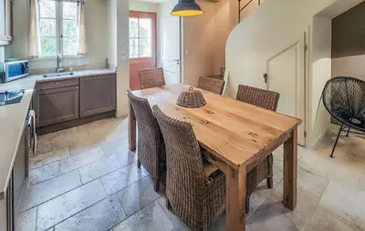 a kitchen with a wooden table and some chairs at Nice Home In Saint-Laurent-De-La-Ca in Saint-Laurent-de-la-Cabrerisse