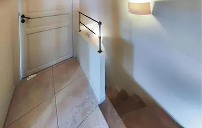 a hallway with a staircase with a door and a light at Nice Home In Saint-Laurent-De-La-Ca in Saint-Laurent-de-la-Cabrerisse