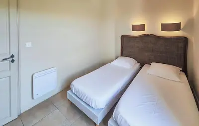 two beds in a small room with a door at Nice Home In Saint-Laurent-De-La-Ca in Saint-Laurent-de-la-Cabrerisse