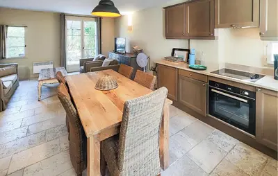 a kitchen and living room with a wooden table and chairs at Nice Home In Saint-Laurent-De-La-Ca in Saint-Laurent-de-la-Cabrerisse