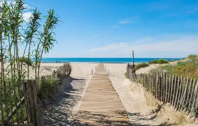 a wooden path to the beach with the ocean in the background at 2 Bedroom Cozy Home In Saint-Laurent-De-La-Ca in Saint-Laurent-de-la-Cabrerisse