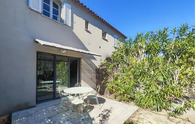 a patio with a table and chairs next to a building at 2 Bedroom Cozy Home In Saint-Laurent-De-La-Ca in Saint-Laurent-de-la-Cabrerisse