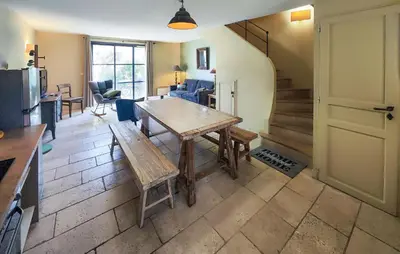a living room with a wooden table and a kitchen at Lovely Home In Saint-Laurent-De-La-Ca in Saint-Laurent-de-la-Cabrerisse