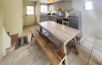 a kitchen with a wooden table and a refrigerator at Lovely Home In Saint-Laurent-De-La-Ca in Saint-Laurent-de-la-Cabrerisse