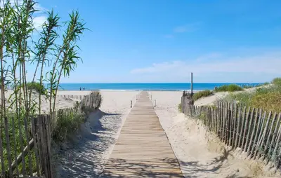 a wooden path to the beach with the ocean in the background at Lovely Home In Saint-Laurent-De-La-Ca in Saint-Laurent-de-la-Cabrerisse
