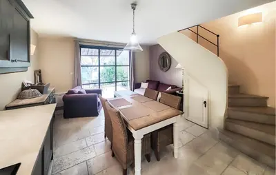 a living room with a dining room table and a staircase at 1 Bedroom Awesome Home In Saint-Laurent-De-La-Ca in Saint-Laurent-de-la-Cabrerisse