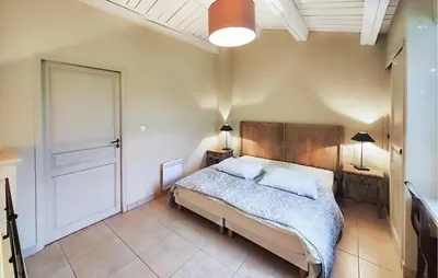 a bedroom with a bed and two lamps and a door at 1 Bedroom Awesome Home In Saint-Laurent-De-La-Ca in Saint-Laurent-de-la-Cabrerisse