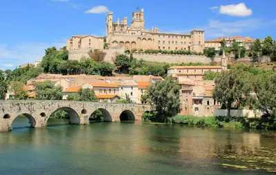 a bridge over a river with a castle in the background at 1 Bedroom Awesome Home In Saint-Laurent-De-La-Ca in Saint-Laurent-de-la-Cabrerisse