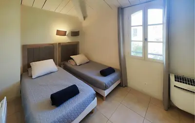 a bedroom with two beds and a window at Nice Home In Saint-Laurent-De-La-Ca With Wifi in Saint-Laurent-de-la-Cabrerisse